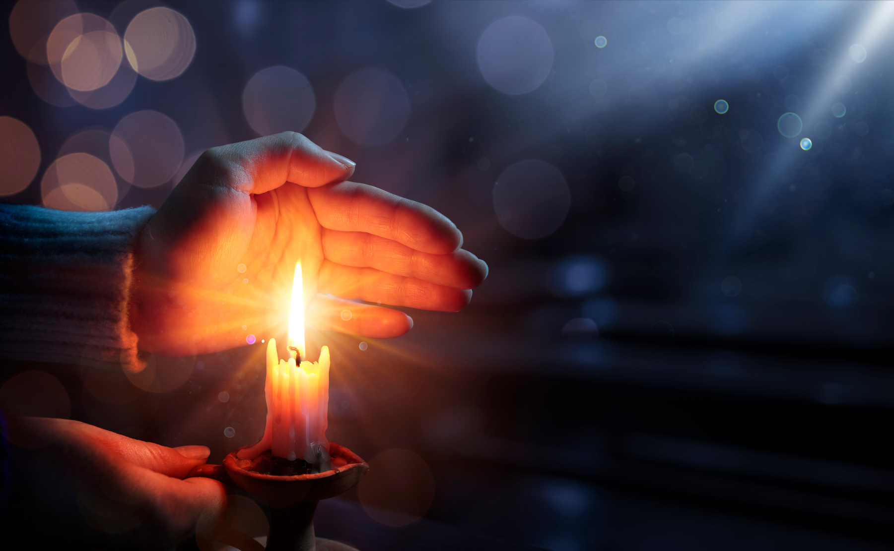 Hope Concept - Hands Holding Candle With Shining Flame And Blurry Lights